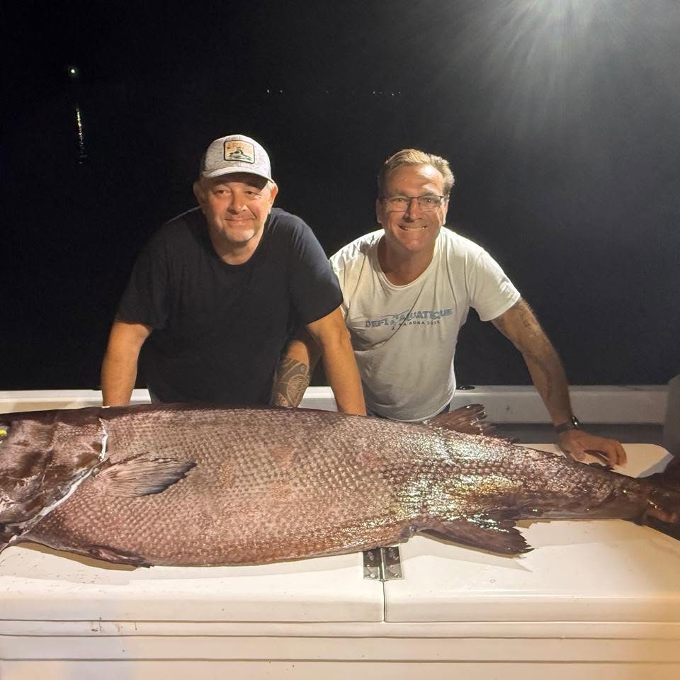 Deux pêcheurs de nuit avec un très gros poisson de fond